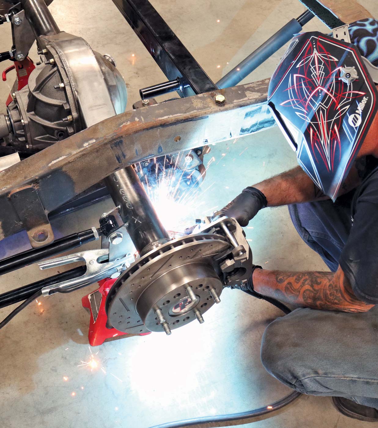 Worker welding rear four-link