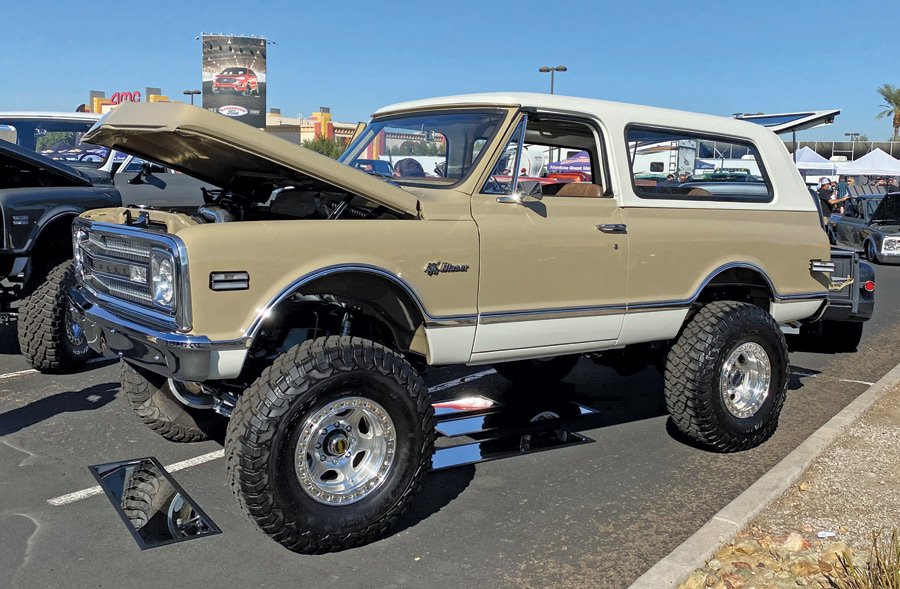 Tan truck with a bed cover and lifted tires
