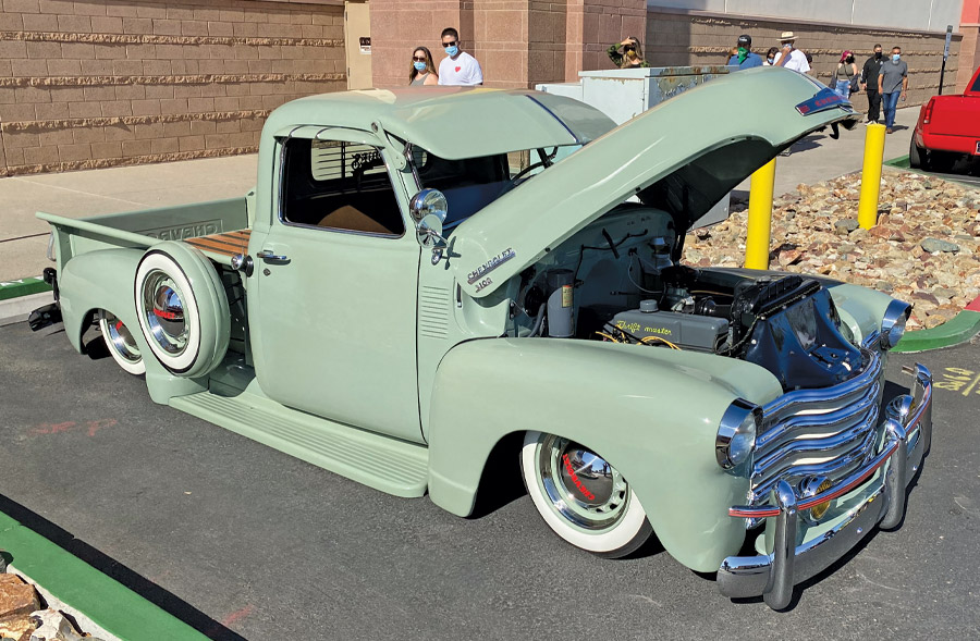 green truck with hood popped open