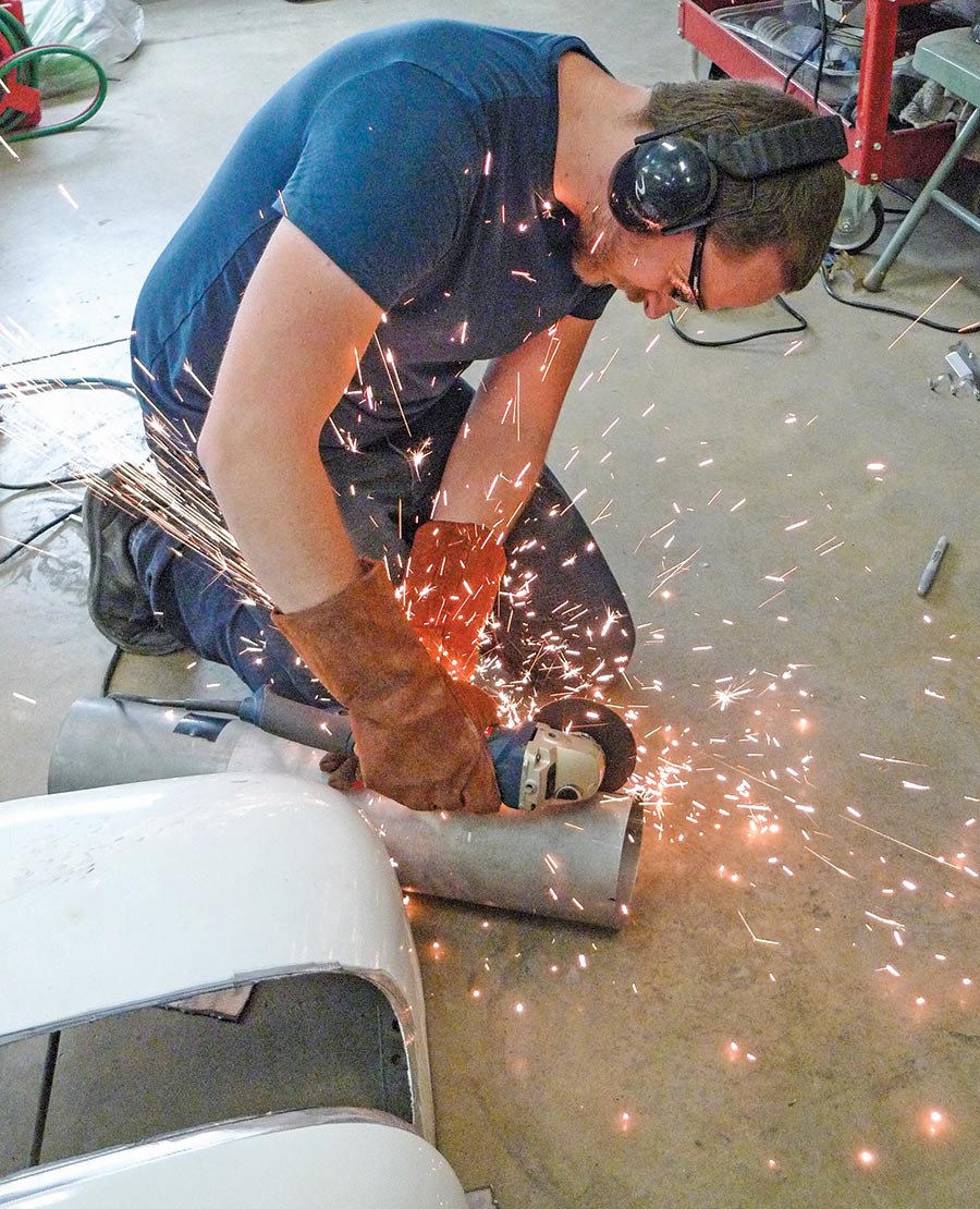 Hart slicing away the first unwanted section of the tubular tunnel with an electric grinder