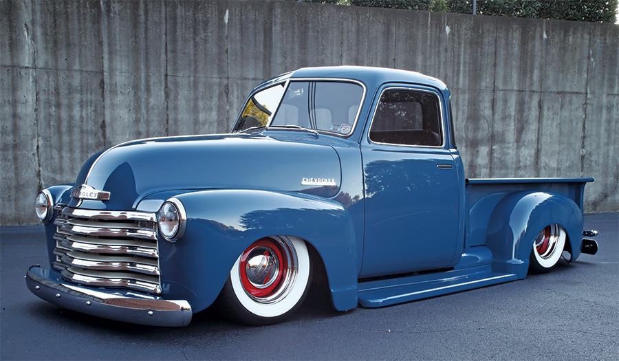 frontal view of 1949 Chevy 3100 grill and tires in parking lot