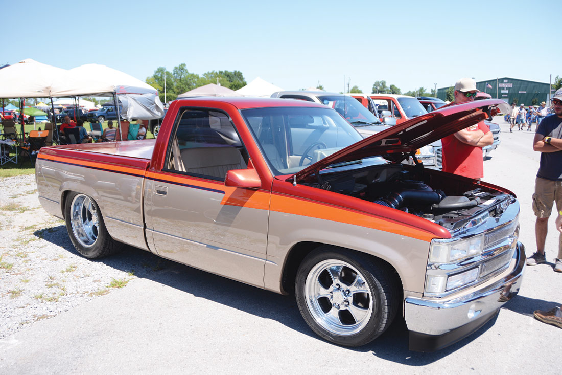 Red, tan and orange color block GMC truck with hood raised