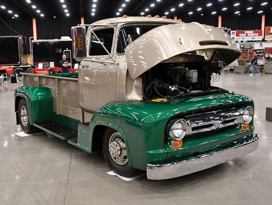 Green and gold F-100 with hood up in showroom