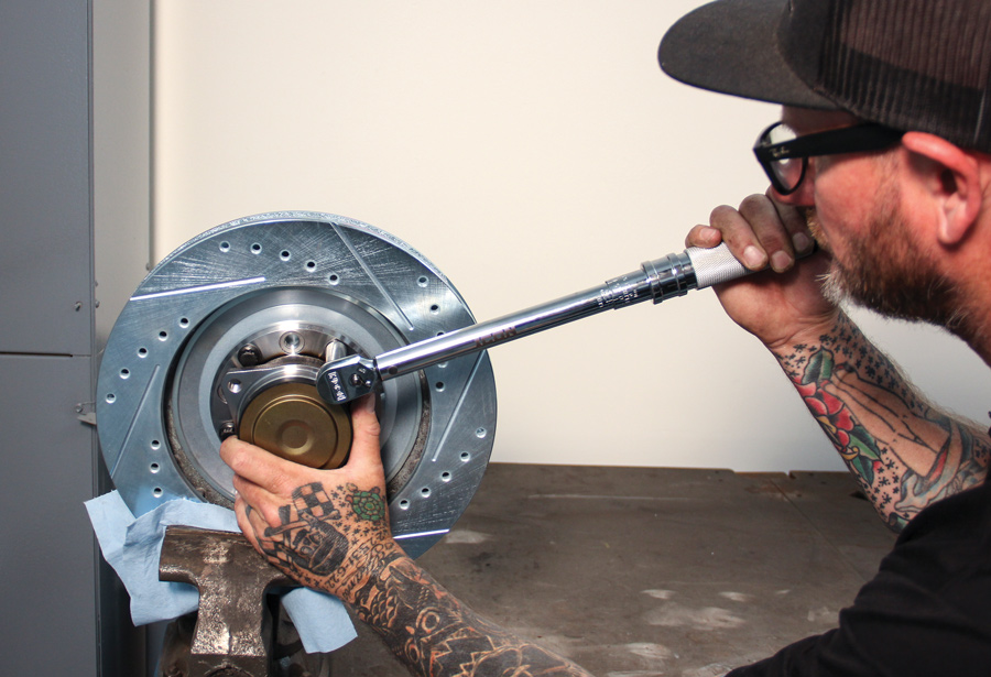we use a vise-secured brake rotor as a “jig” to hold the hub in place
