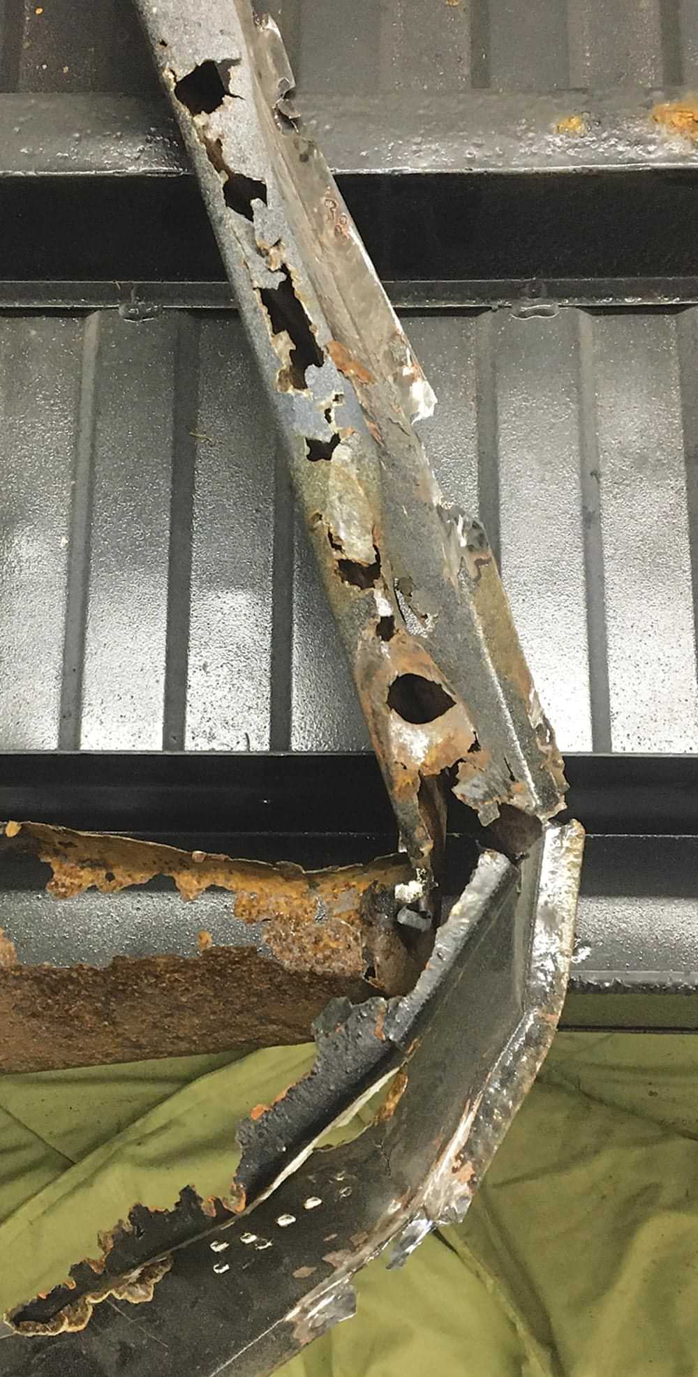 a warped and rusted U-channel crossmember