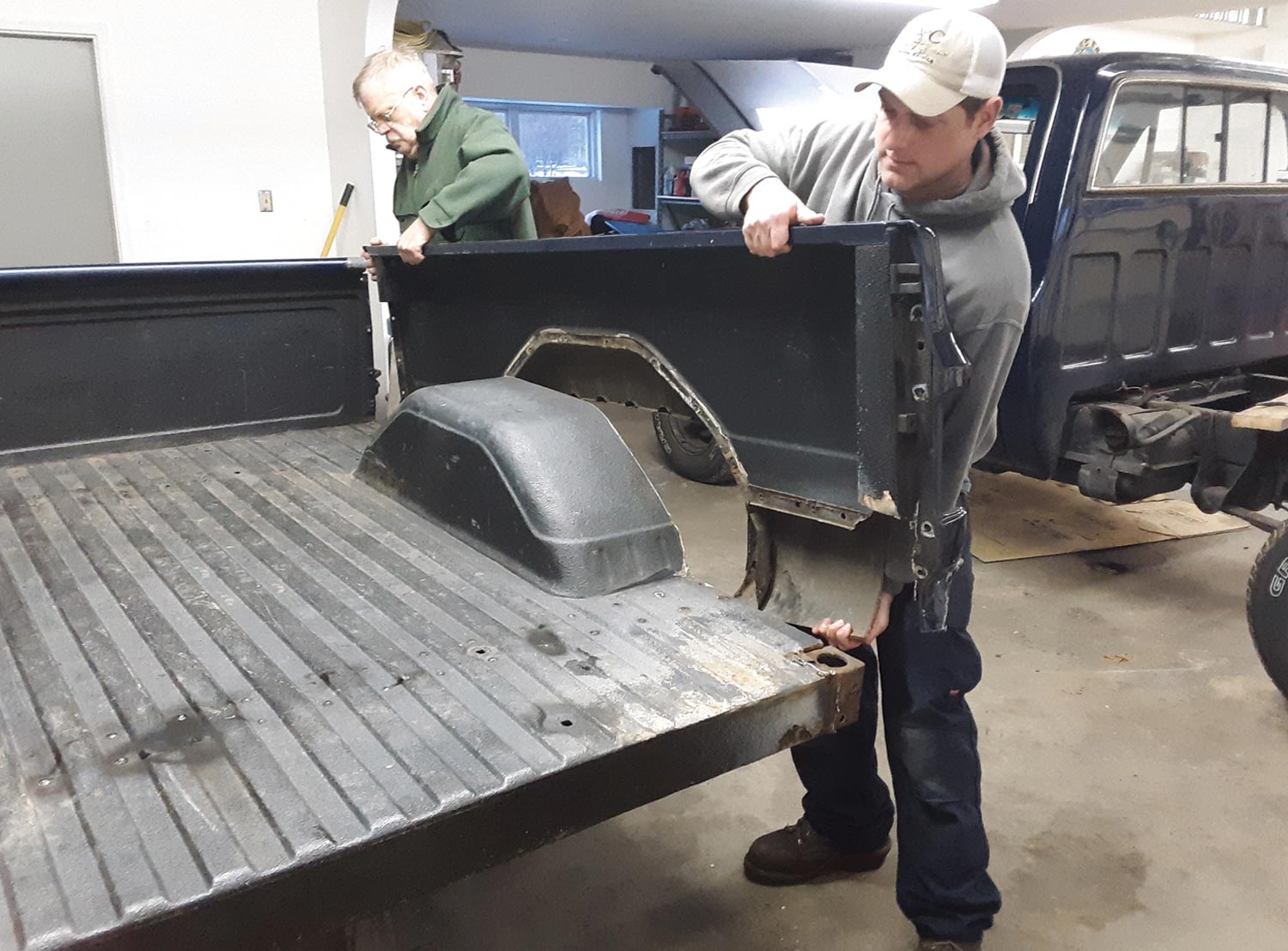 two mechanics remove the truck bed sides with surprising ease