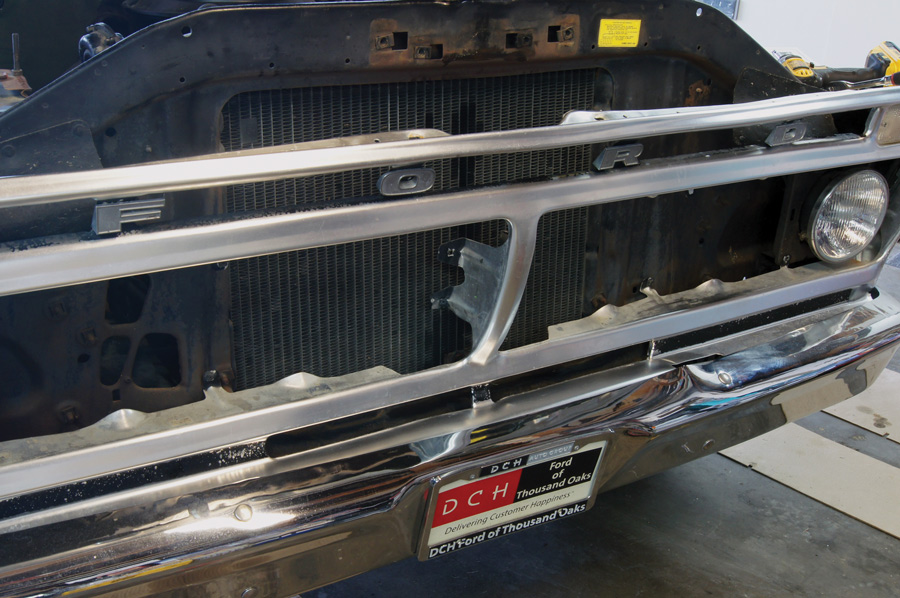 The hood latch and support and the grille inserts are removed