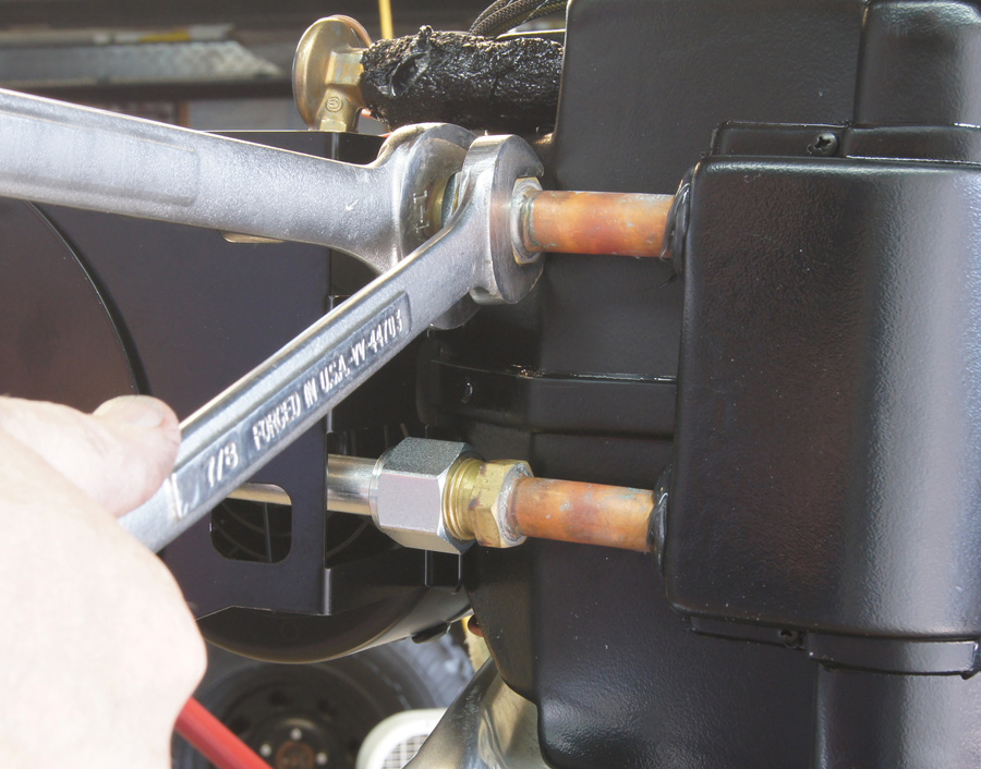 With the evaporator on the bench (or in this case sitting on the inner fender), the brackets are installed and the hard lines are put in place