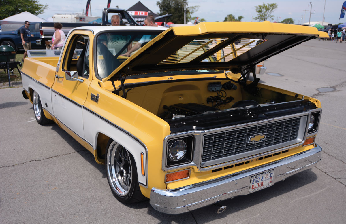 Yellow Chevy truck with white trim and an open hood