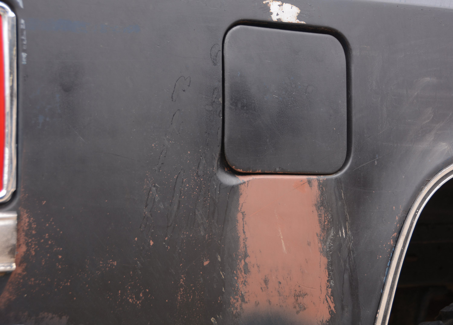 view of the fuel door with faded paint directly below