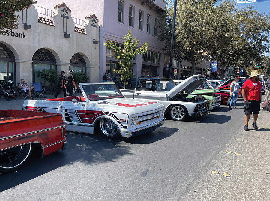 various cars parked on the street with viewers walking around