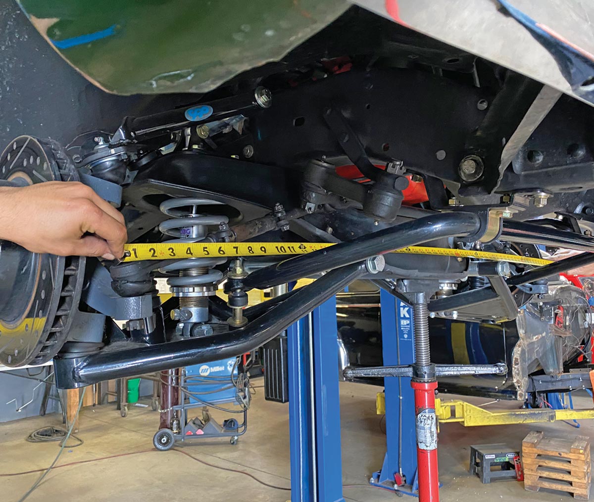 the mechanic takes a measurement from the center of each outer tie rod end (to use when assembling the new steering linkage)