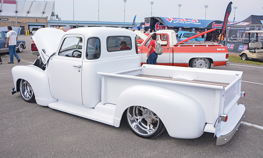 white truck side profile with orange truck behind it