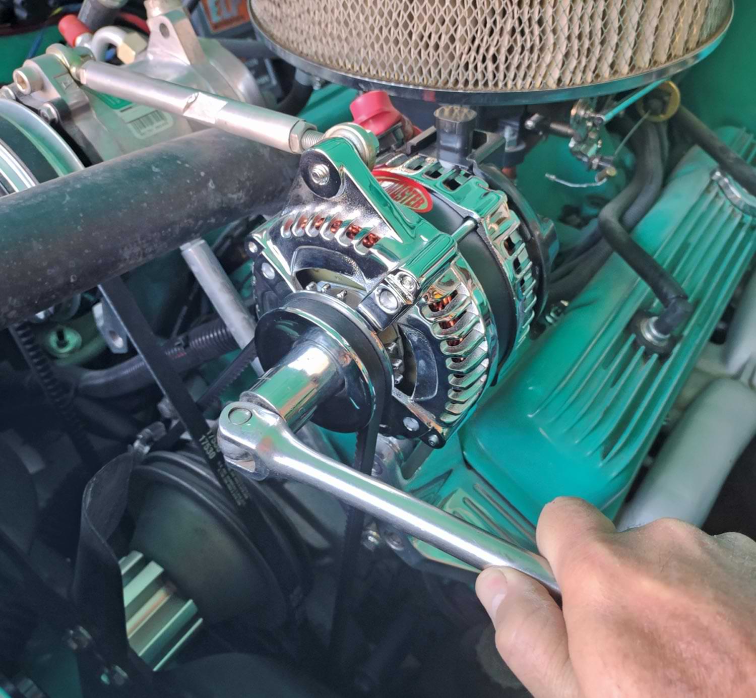 mechanic tightens bolt of the newly installed alternator
