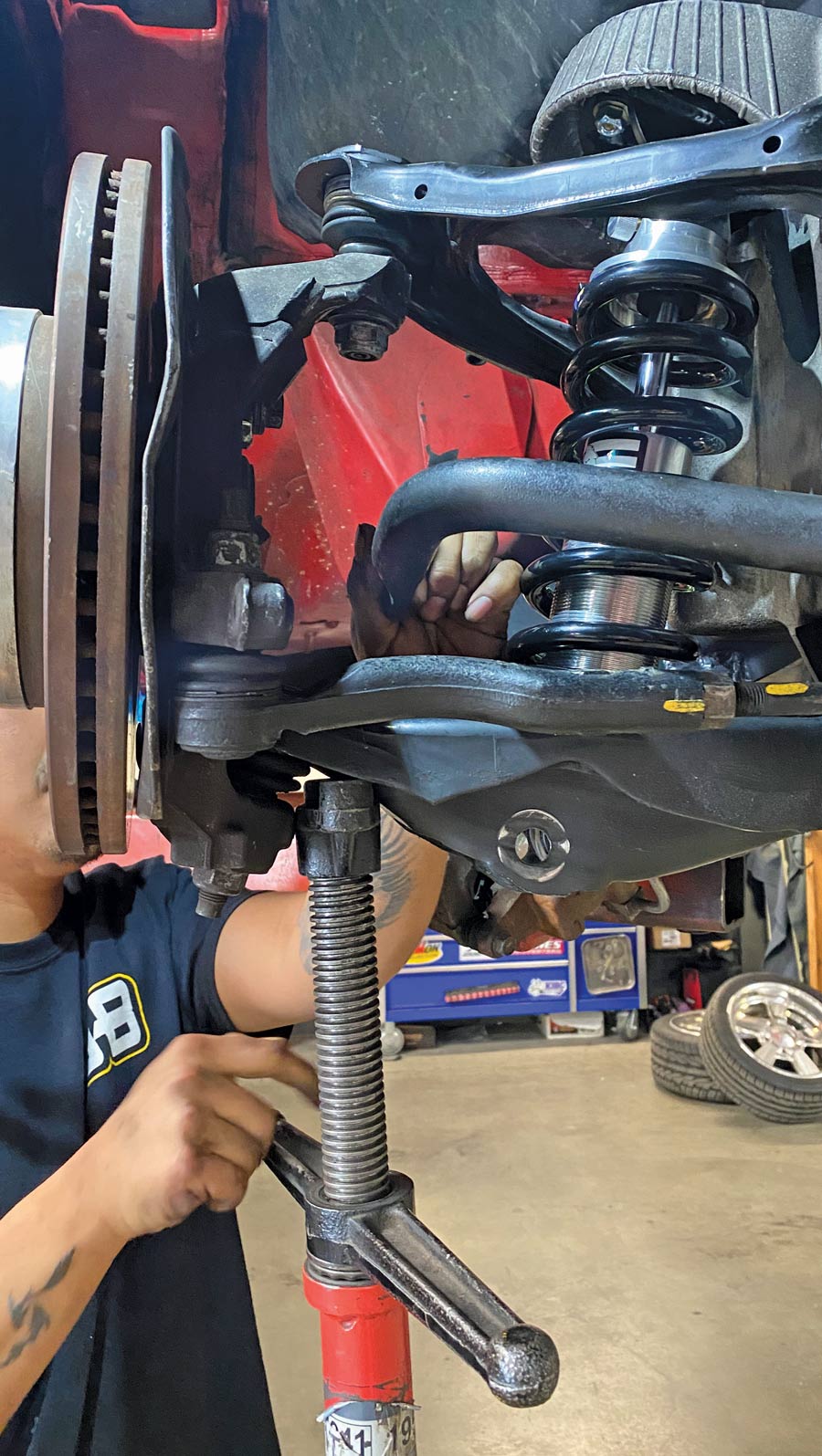 using our adjustable jackstand, the lower control arm is carefully raised up to allow the upper ball joint to be reinstalled into the spindle