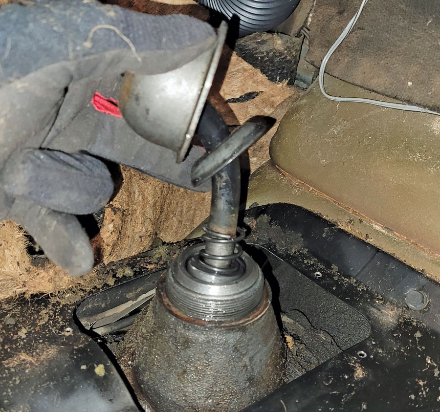 First step was to peel back the crumbling rubber mat, remove the cracked rubber boot, and unscrew the giant nut holding the shifter to the trans.