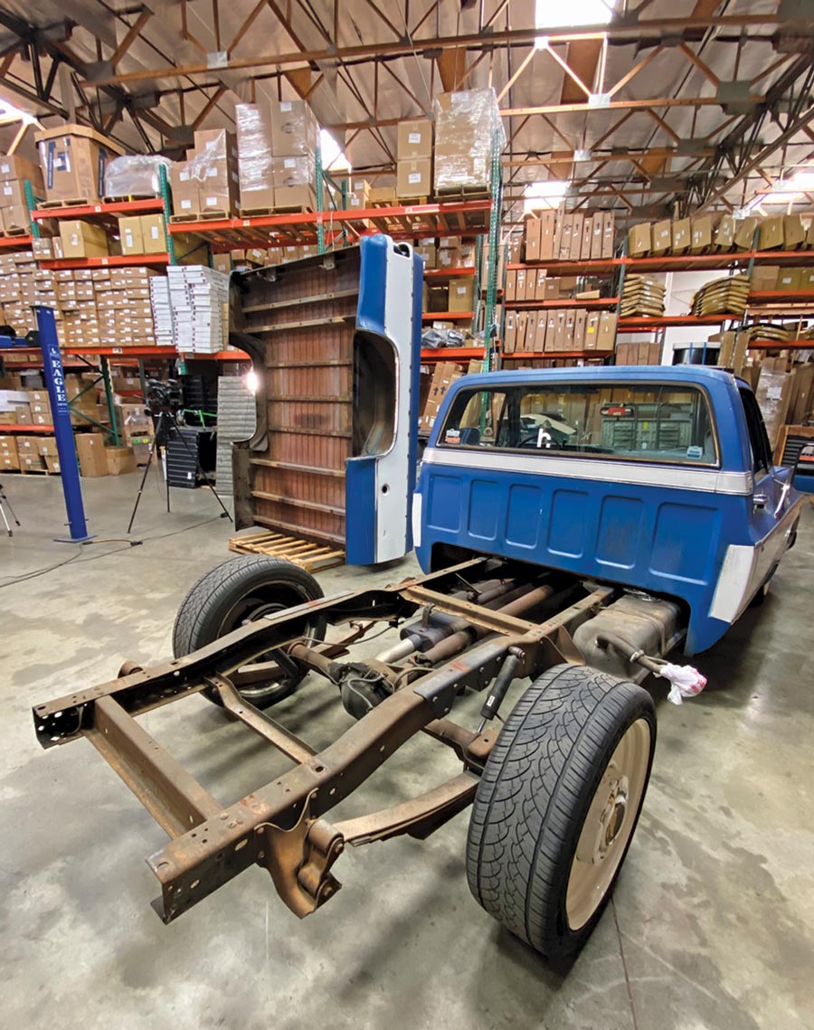 blue Chevy truck with the truck bed removed showing the truck bed frame