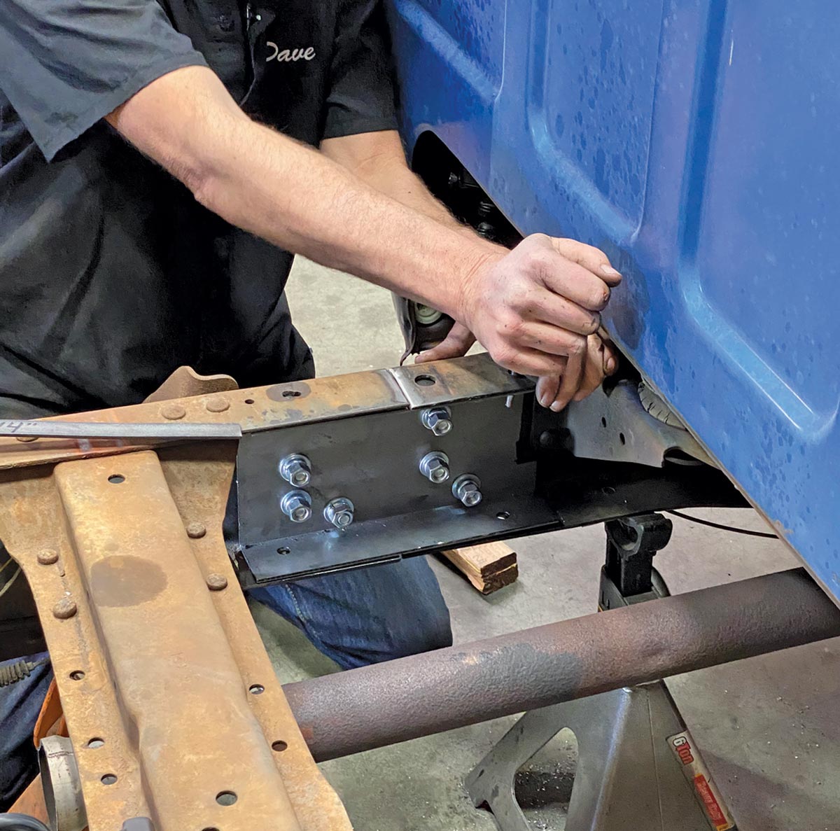mechanic adjusts the sections of frame until the holes previously drilled align with the holes in the C-channel