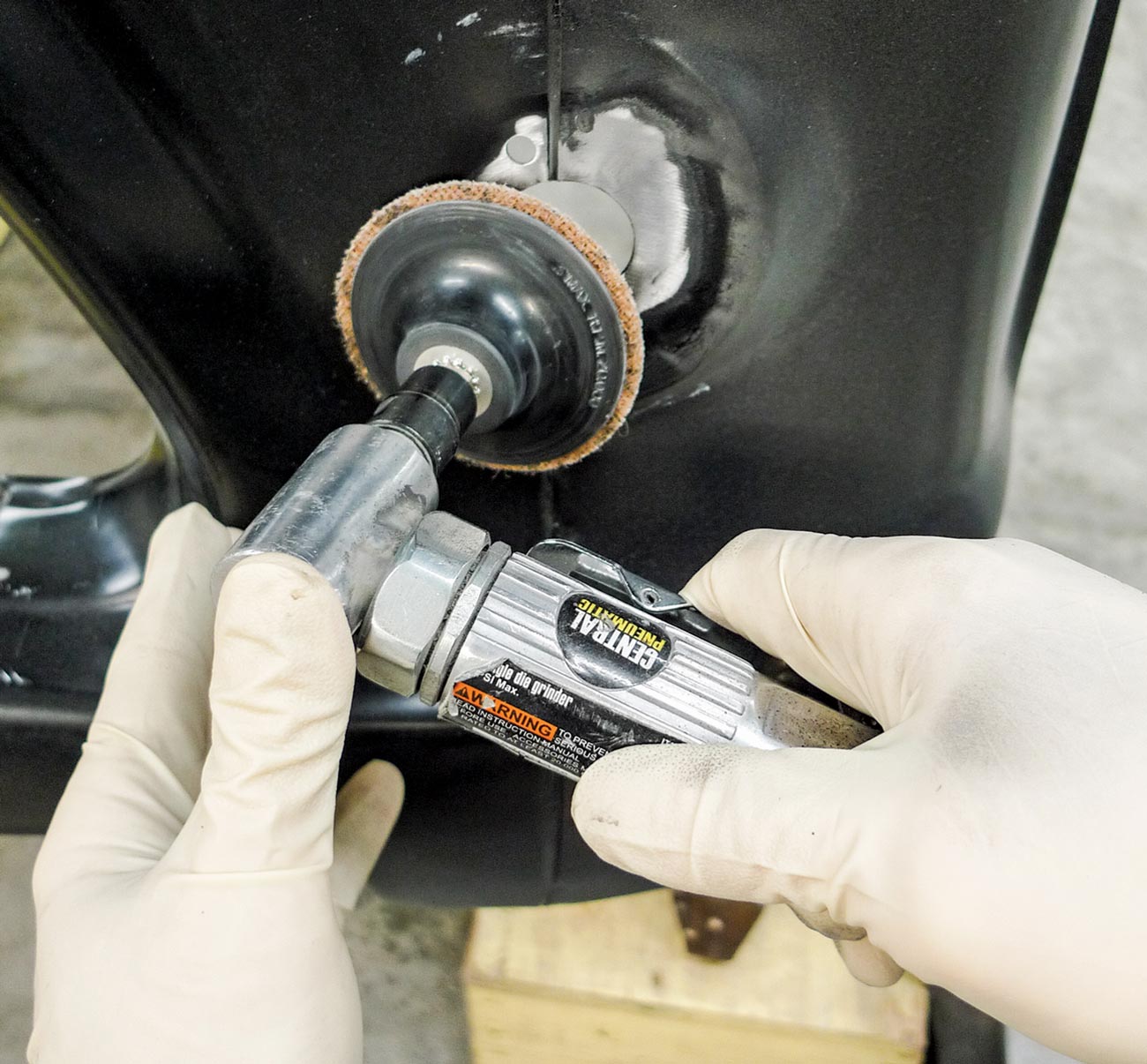 mechanic removes an area of EDP coating from the right fender