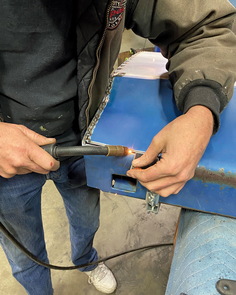using a safety blade as a tool to further help in keeping his seam aligned as he incrementally tack-welds