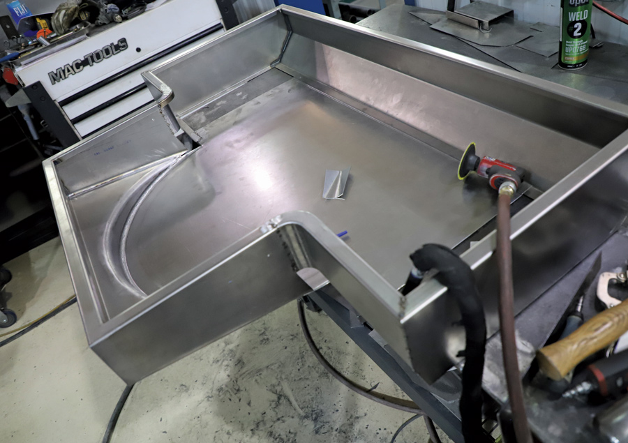 This custom tray fits above the fuel tank and provides another storage space and a place for a spare tire (note the recess that provides the necessary underfloor clearance). 