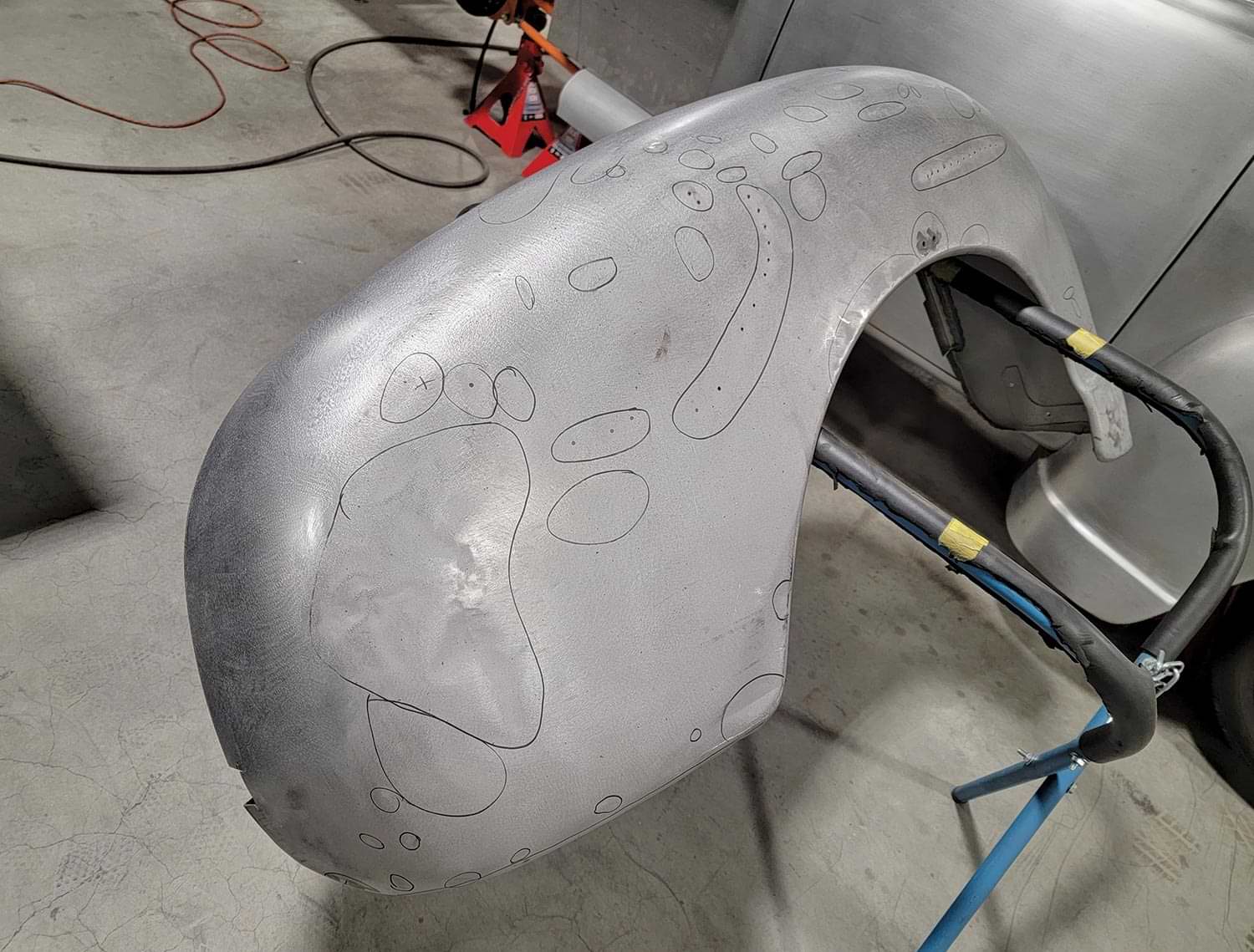 the passenger side back fender with markings indicating areas of needed metalwork