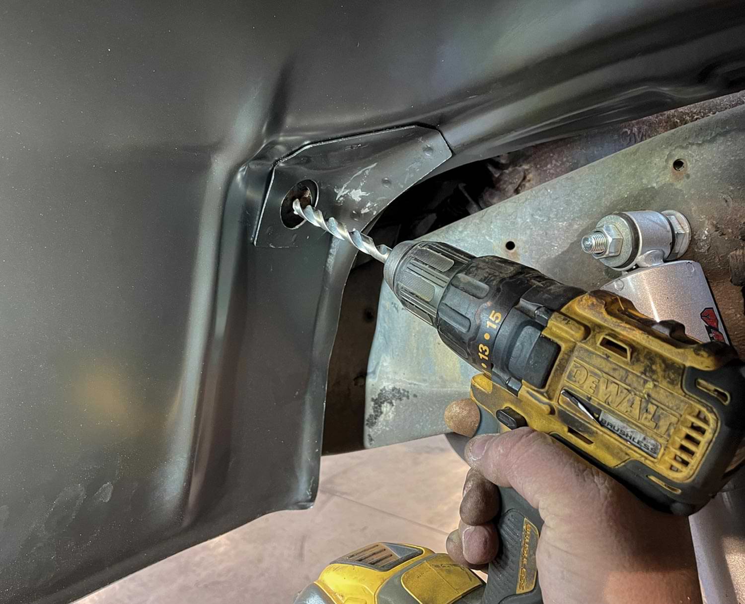mechanic uses a drill while installing the inner brace