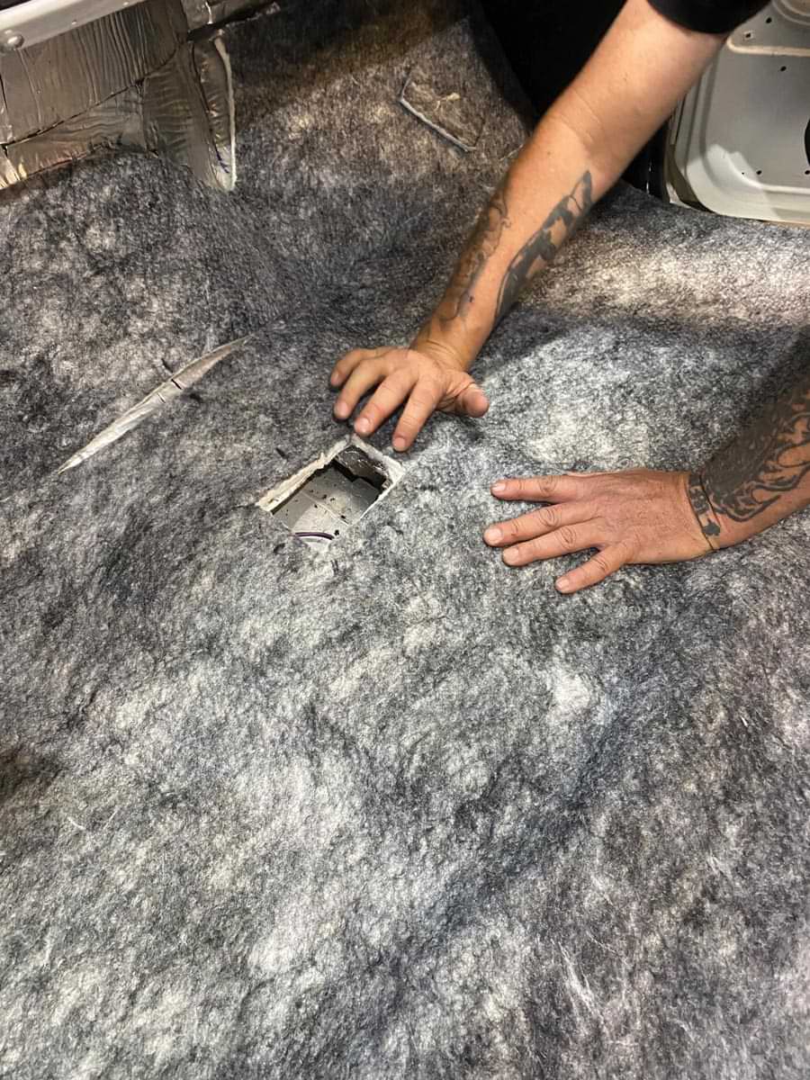mechanic attaches the Under Carpet Lite material to the middle of the cab floor