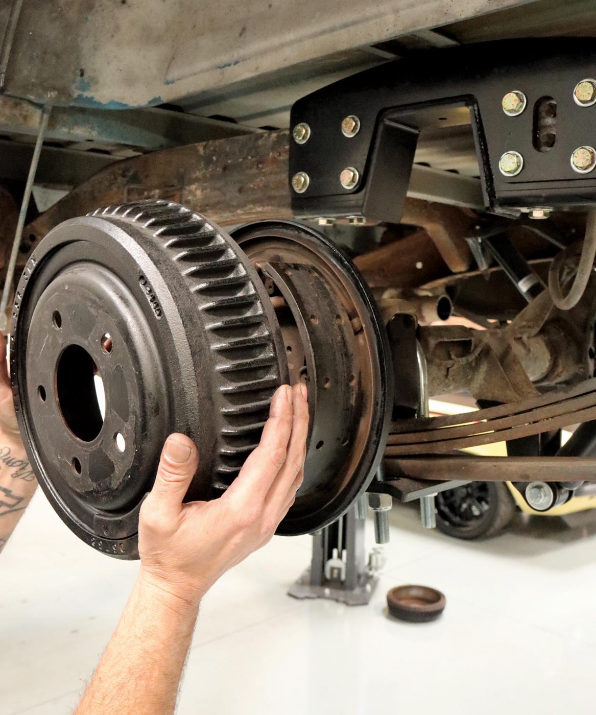 mechanic begins removing the axles starting with the drum brake