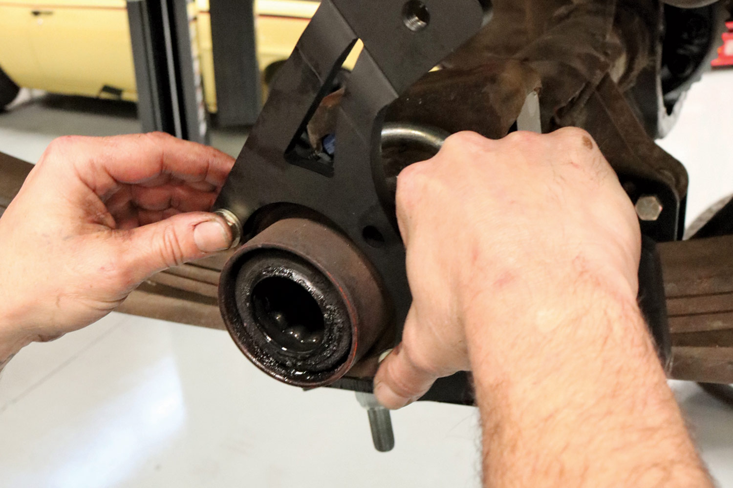 mechanic installs a caliper bracket to an axle