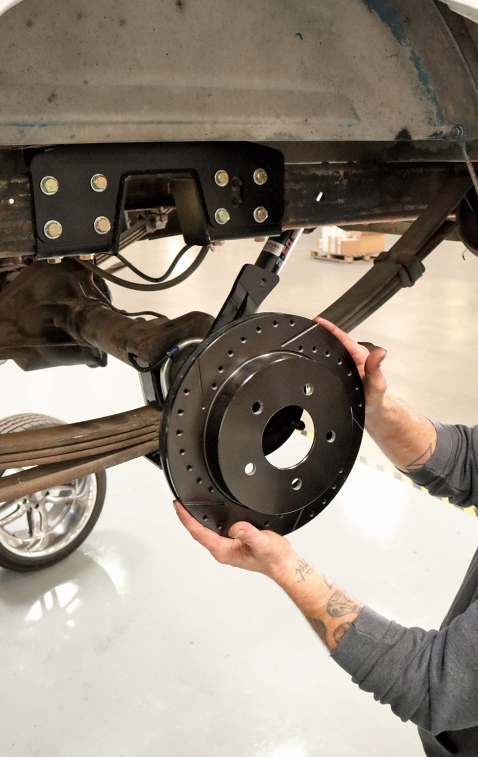 mechanic carefully installs the 11.75-inch rotors to the axle
