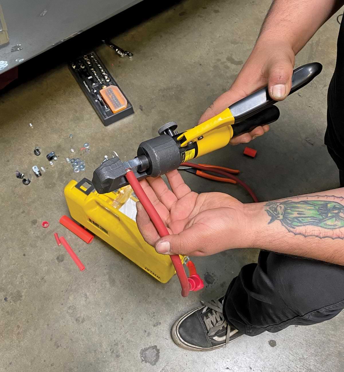 mechanic cuts the correct length for the battery cable