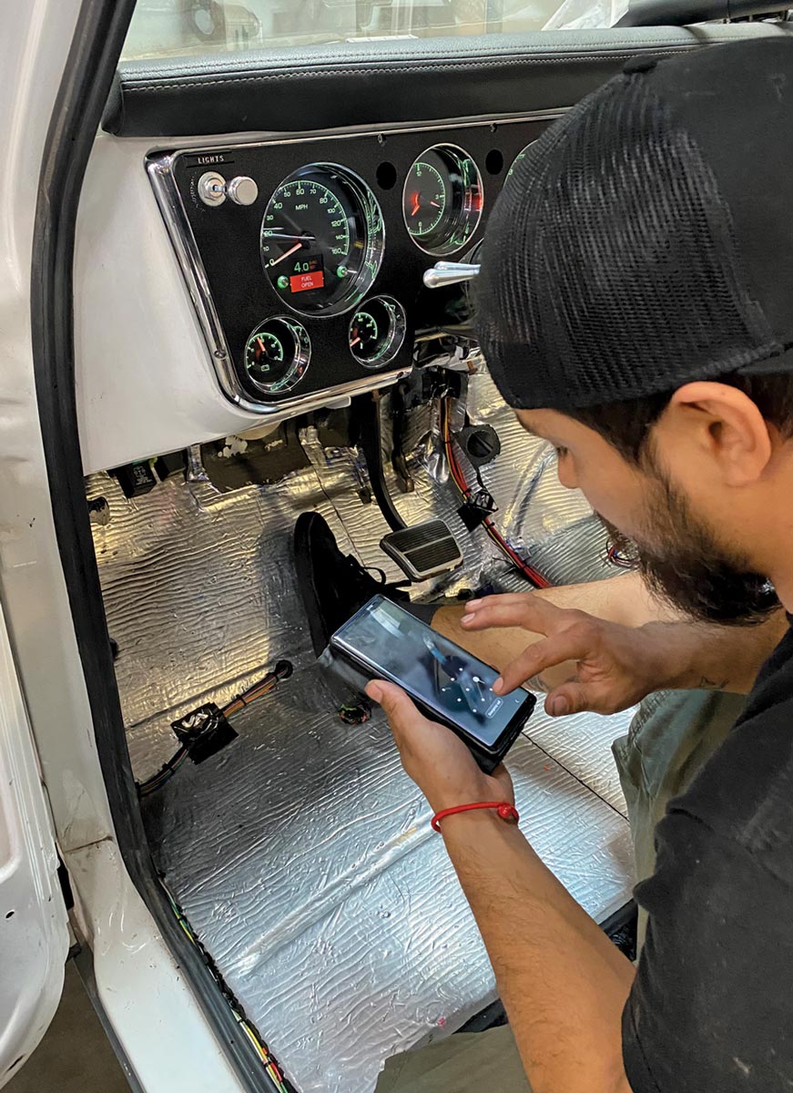 mechanic sits at the driver side using a smart phone