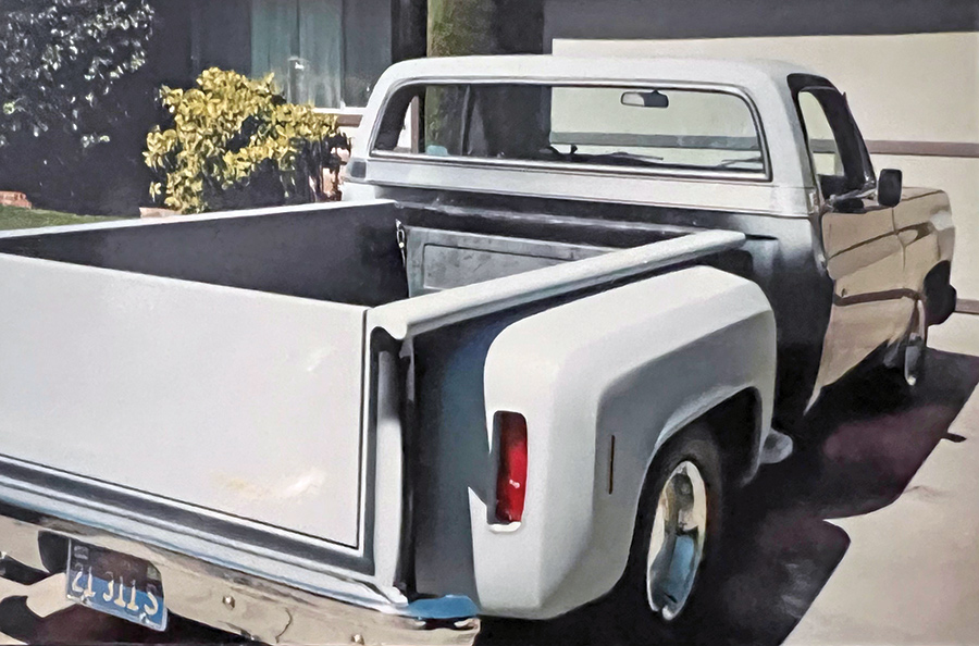 A back view photograph perspective of a 1974 Chevrolet Stepside Pickup Truck parked in a home's driveway