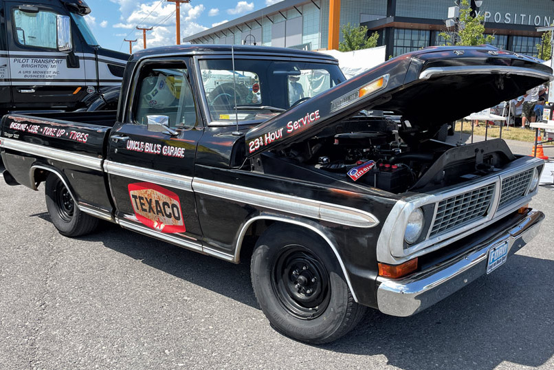 Black classic pickup truck with the hood opened and "texaco" written on the side