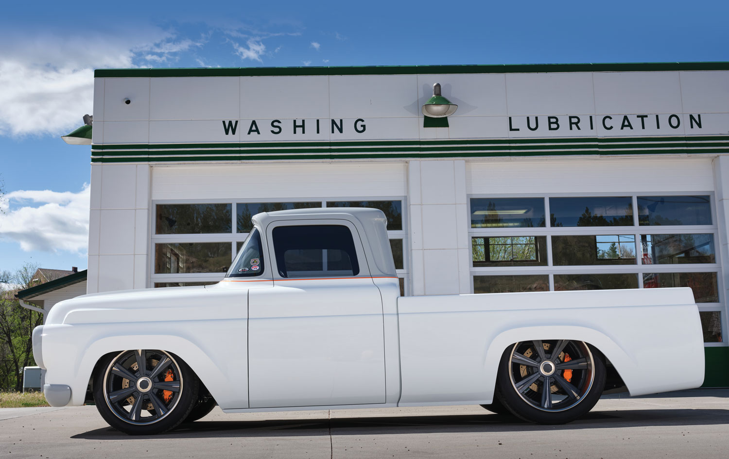 white '58 Ford F-100 in front of a garage