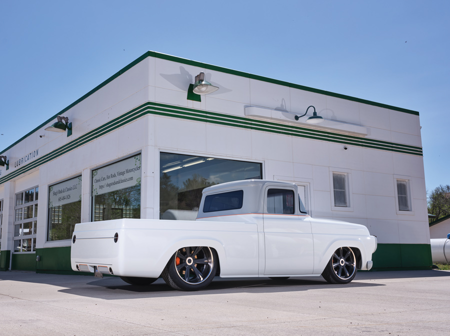white '58 Ford F-100 in front of a garage
