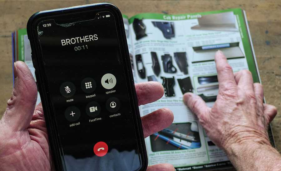 A picture of someone holding a phone and book on the table