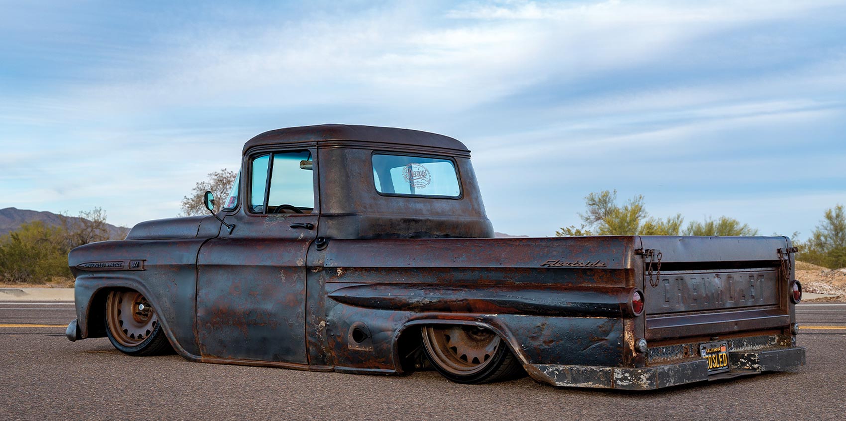 three quarter rear view of the '59 Apache parked on a desert highway