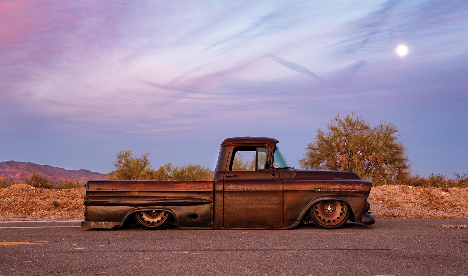 passenger side profile view of the '59 Apache against a pink and blue dusk sky