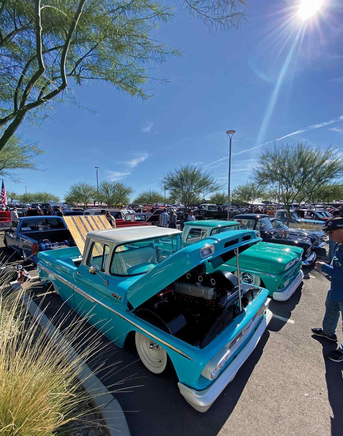 three quarter passenger side view of a turquoise classic chevy truck with its hood and truck bed raised