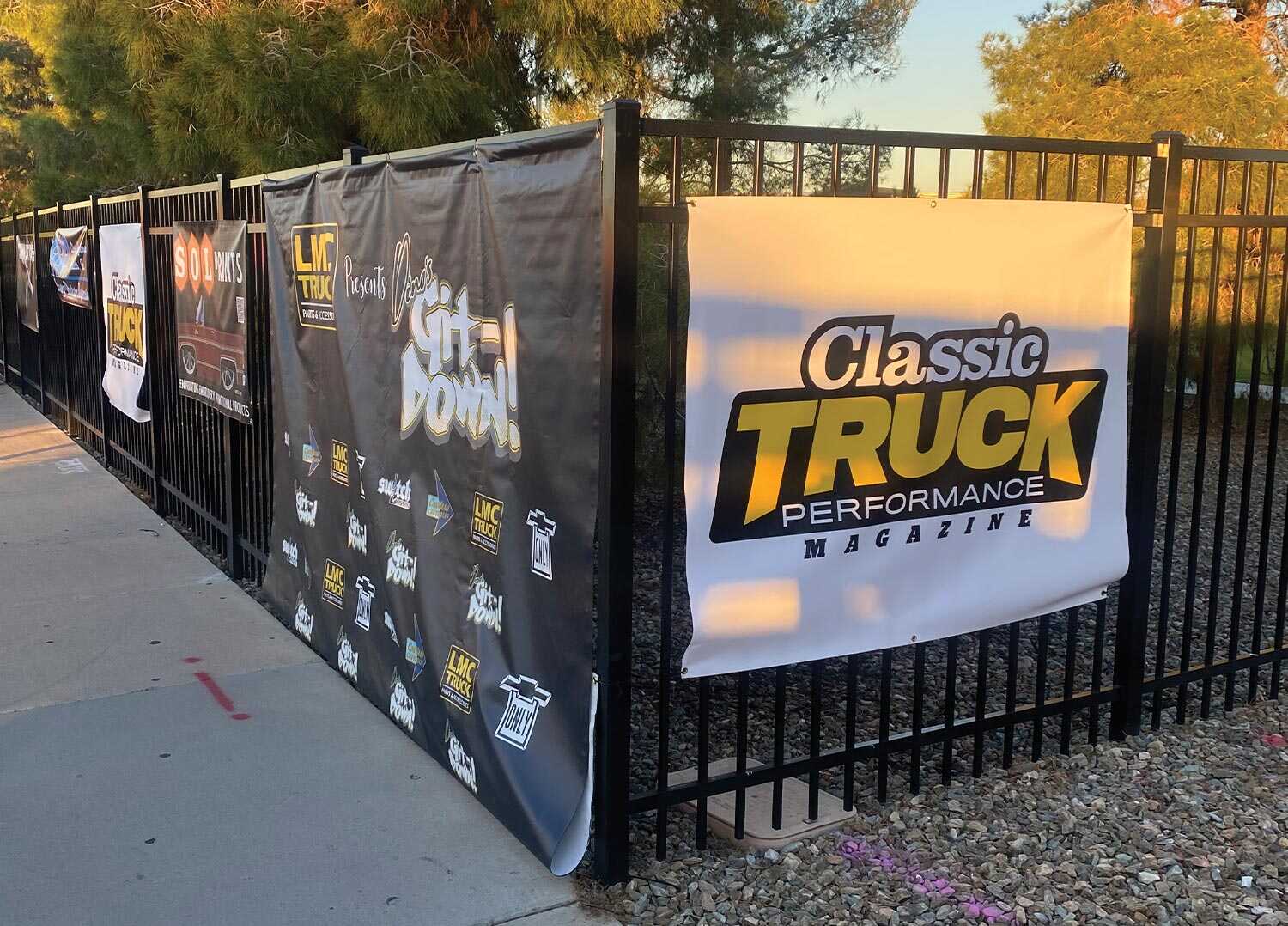 a Classic Truck Performance Magazine banner affixed to a metal fence