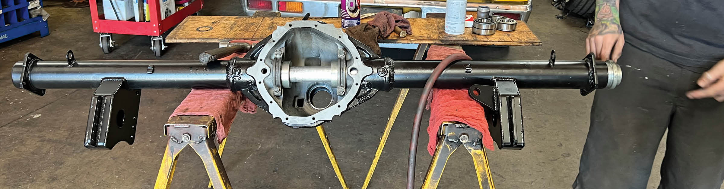 To ensure that the housing was not warped during welding, the alignment is checked with a fixture that has a large-diameter bar that fits through precision collars in the axle ends and the differential bearing caps.