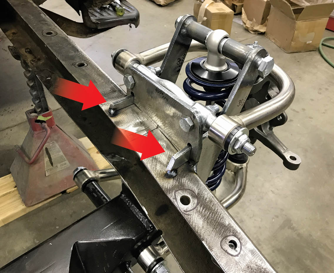 Rather than using Mustang II–type slots for alignment adjustments, this Fatman IFS has vertical plates that the upper control arms attach to. Note how the upper coilover mounts index into the mounting plates for the upper control arms (arrows) for strength and to position them properly.
