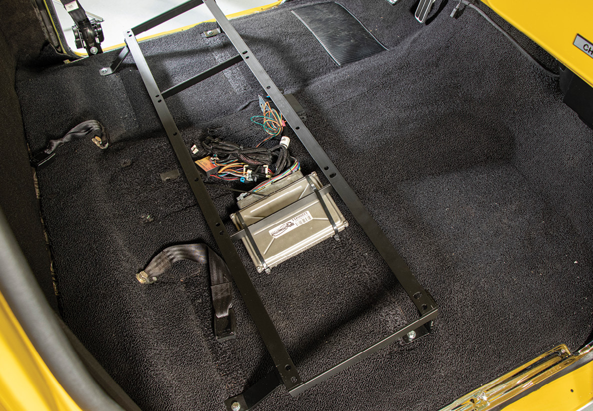 With the old, well-used interior removed down to the base carpet, the first order of business is to install the supplied TMI bucket seat bracket.