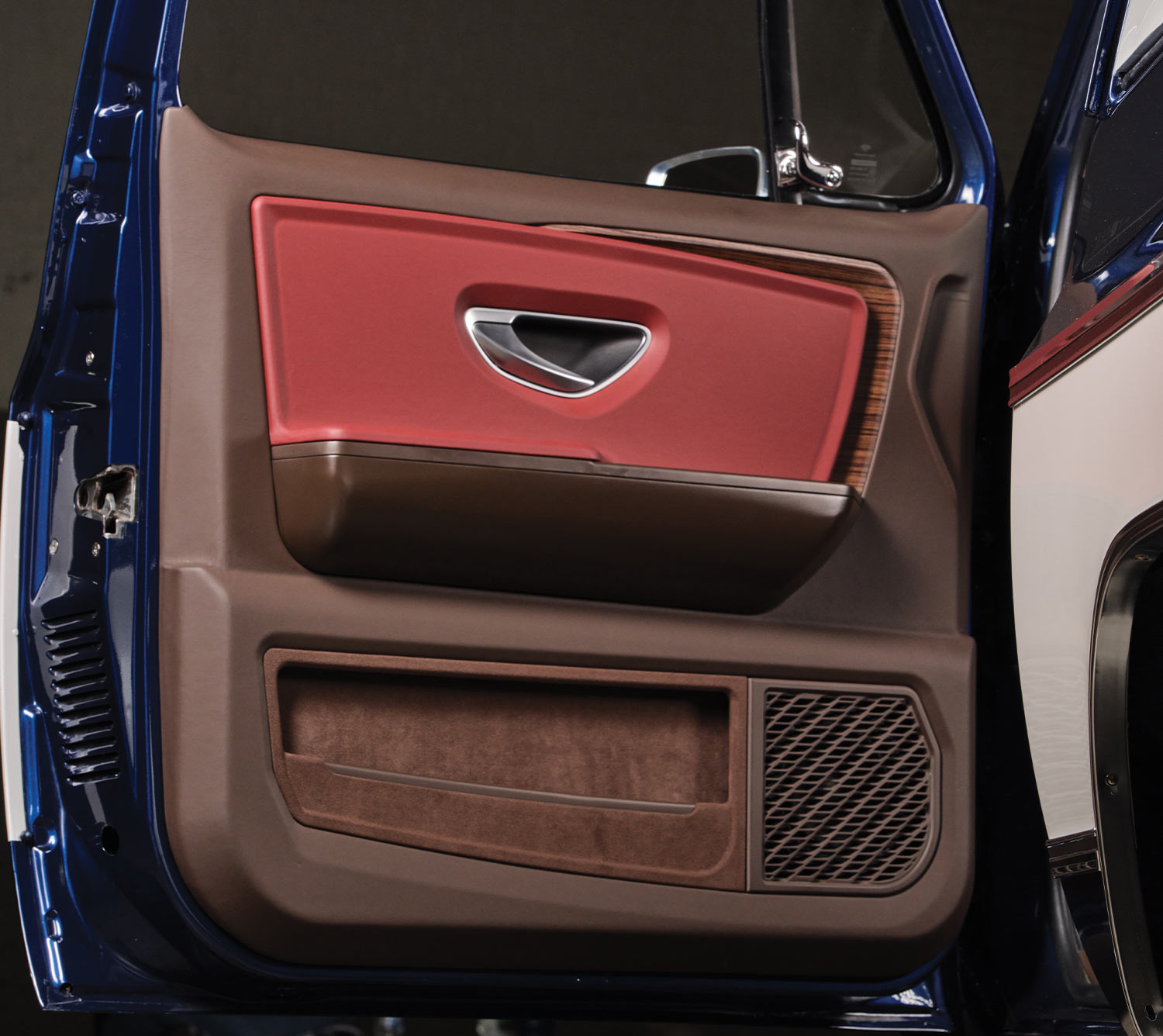 interior side of the driver door, showing the rich dark brown and deep red finish and a brown suede lined door compartment