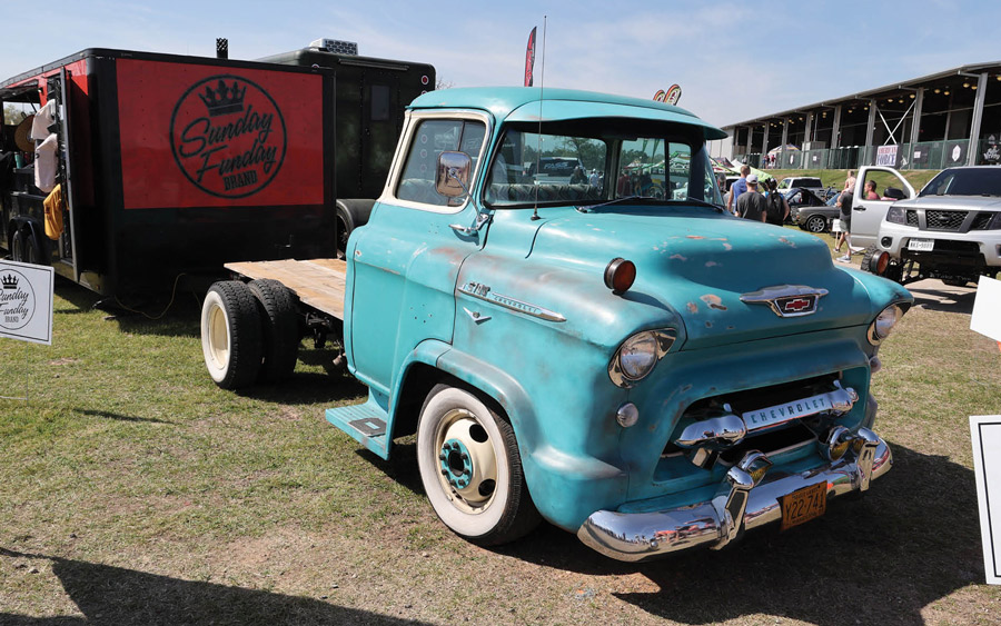 lightly rusted light blue truck with no bed