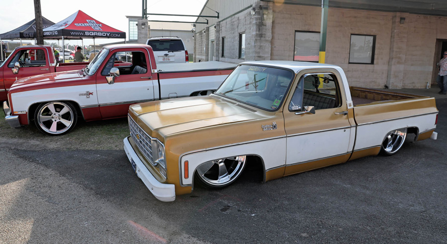 a red truck and a gold truck, both with white sides