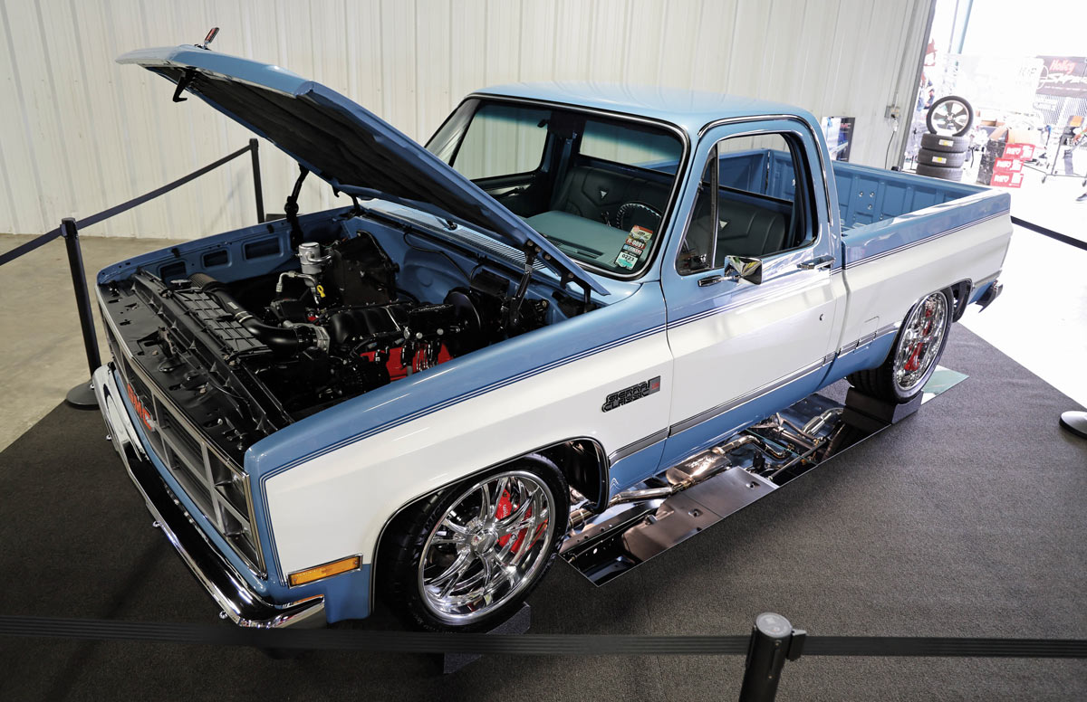blue truck with white side and hood open