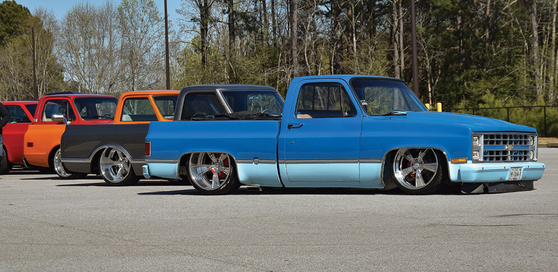 Row of trucks with two tone cornflower blue and powder blue Squarebody at the front